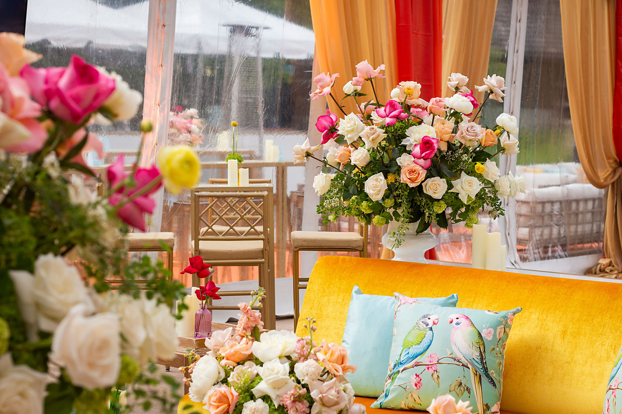 Stylish lounge seating surrounded by colorful floral arrangements indoors.